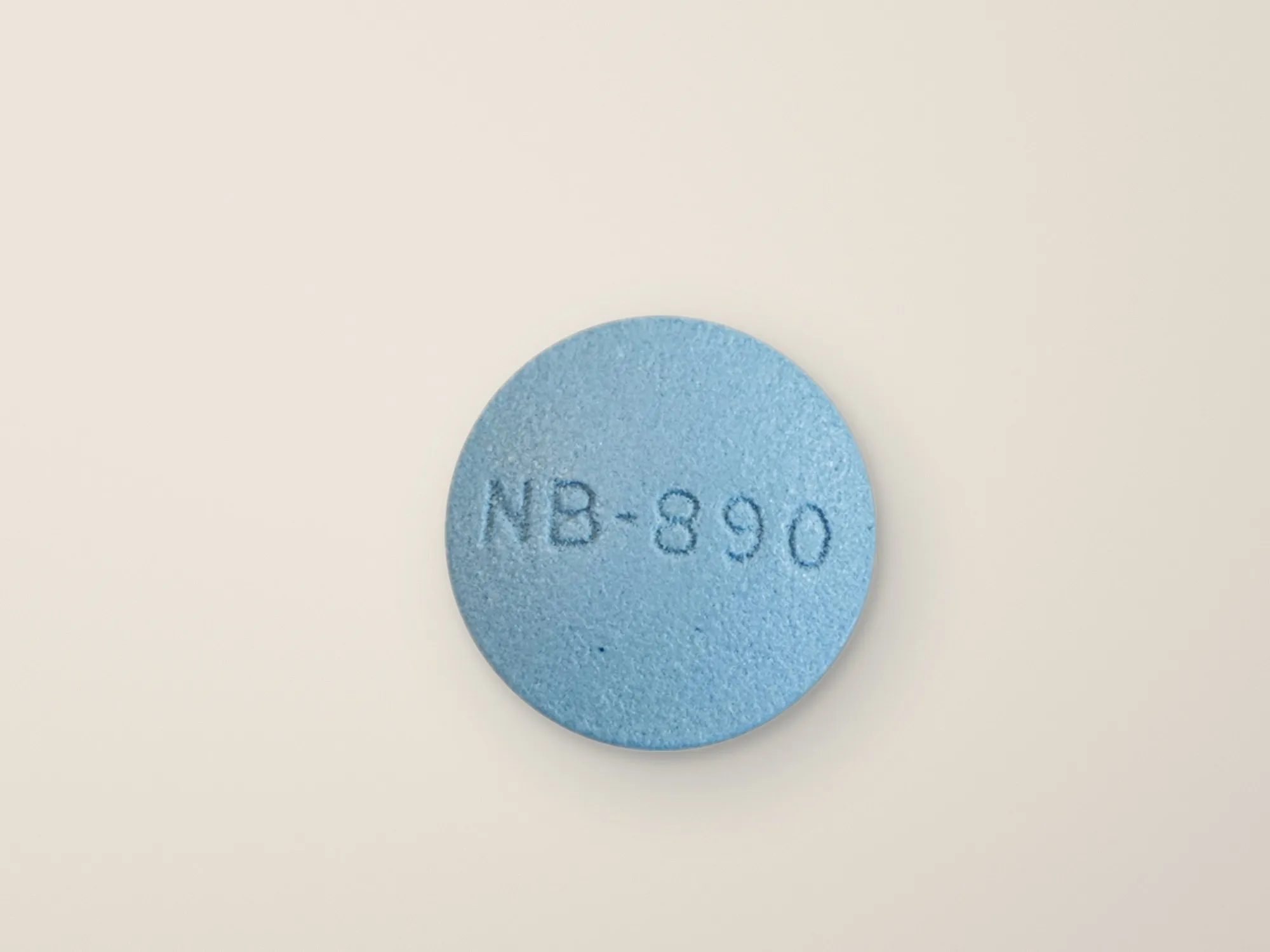Een lichtblauwe tablet op een lichte, zandkleurige ondergrond