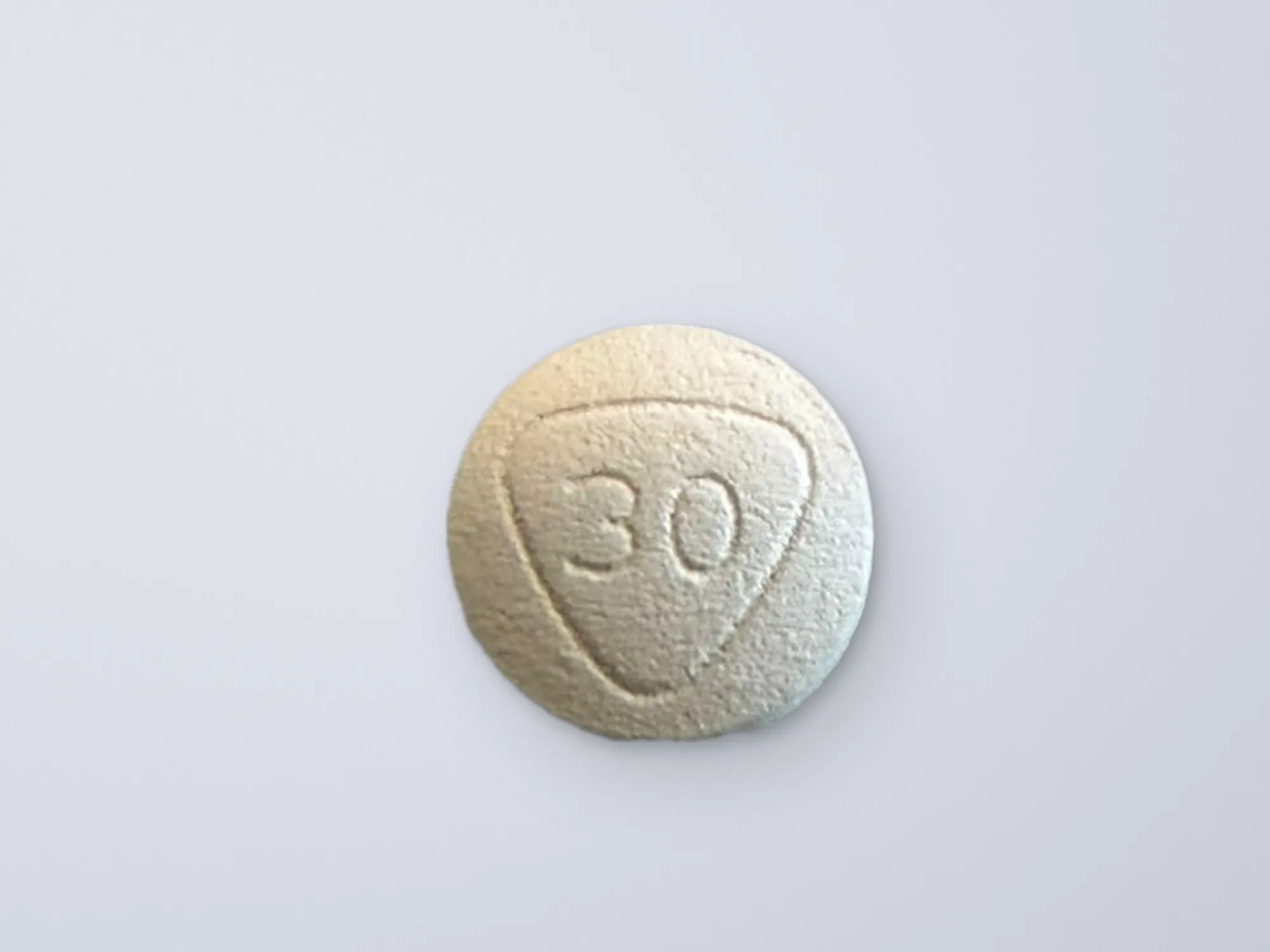 A light grey tablet on a soft, lavender grey background