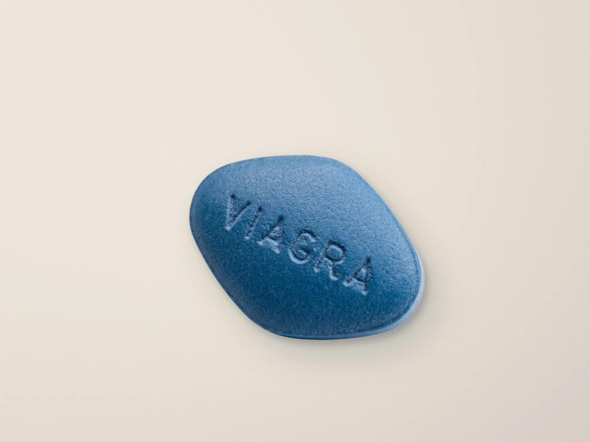 A blue tablet on a light, sand coloured background