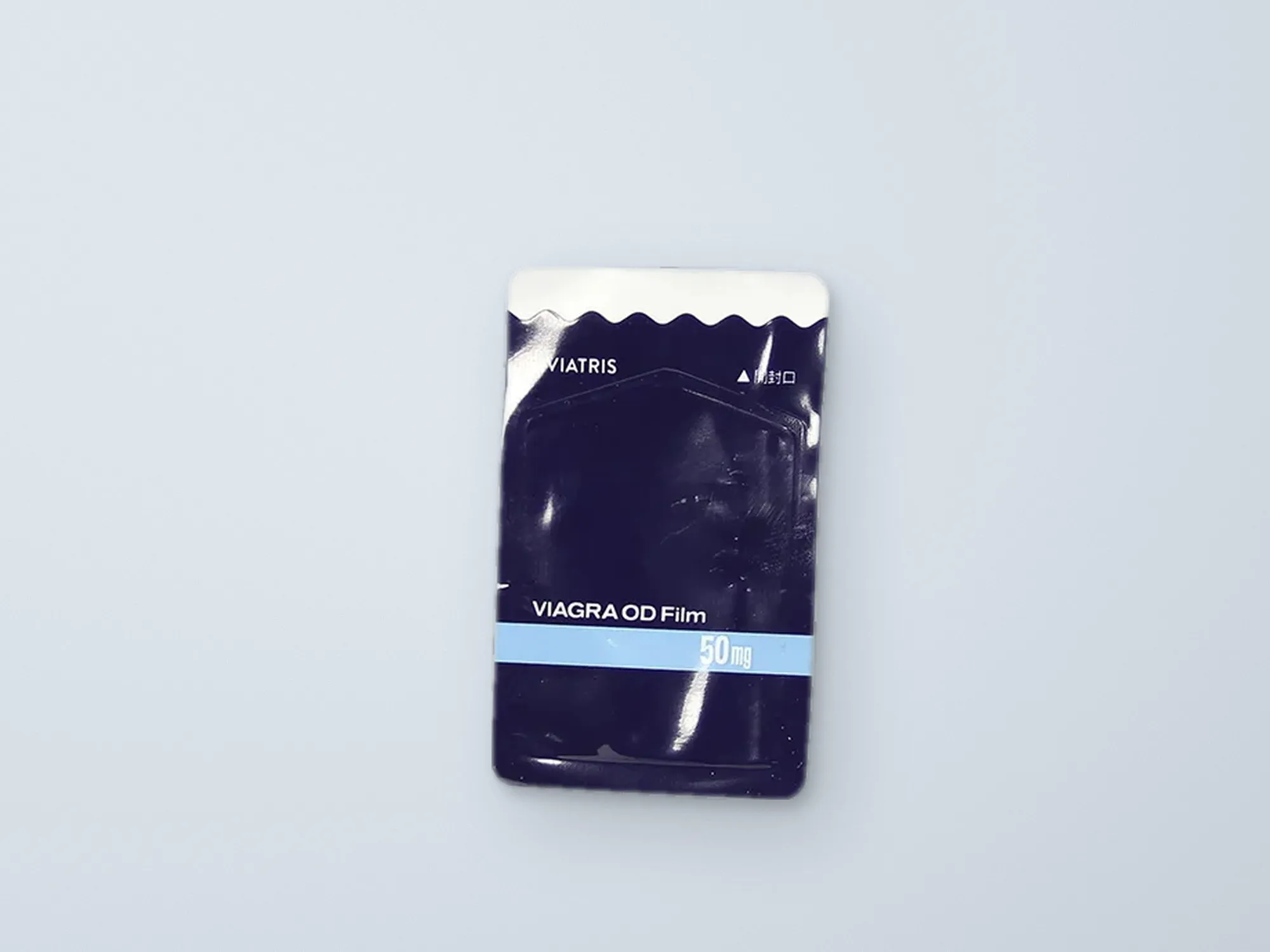 A wrapped orodispersible film on a light, blue grey background